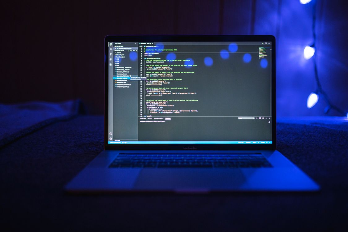Programming code displayed on a laptop screen with blue lighting, representing modern IT skills