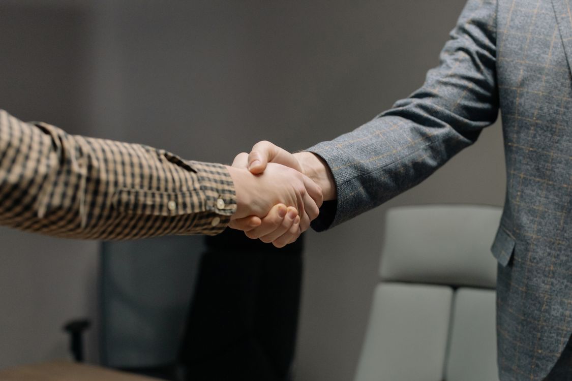 Two IT professionals shaking hands after a successful technical job interview
