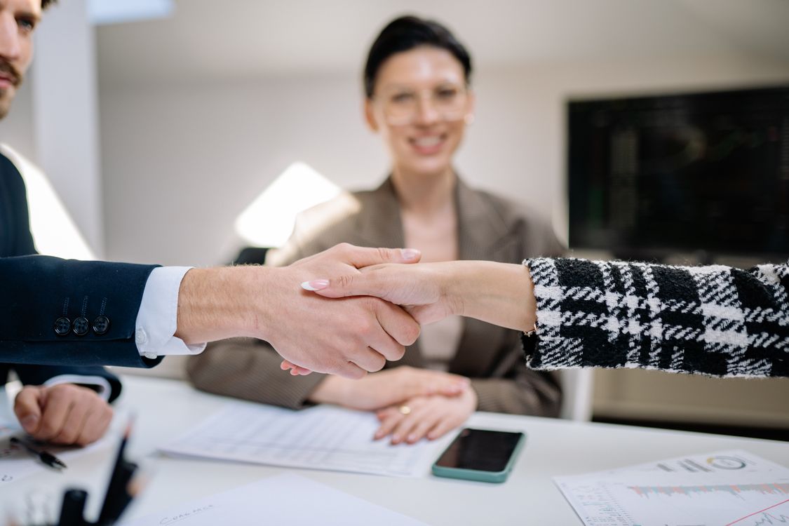 Colleagues shaking hands after reaching a deal, representing accepting a negotiated job offer