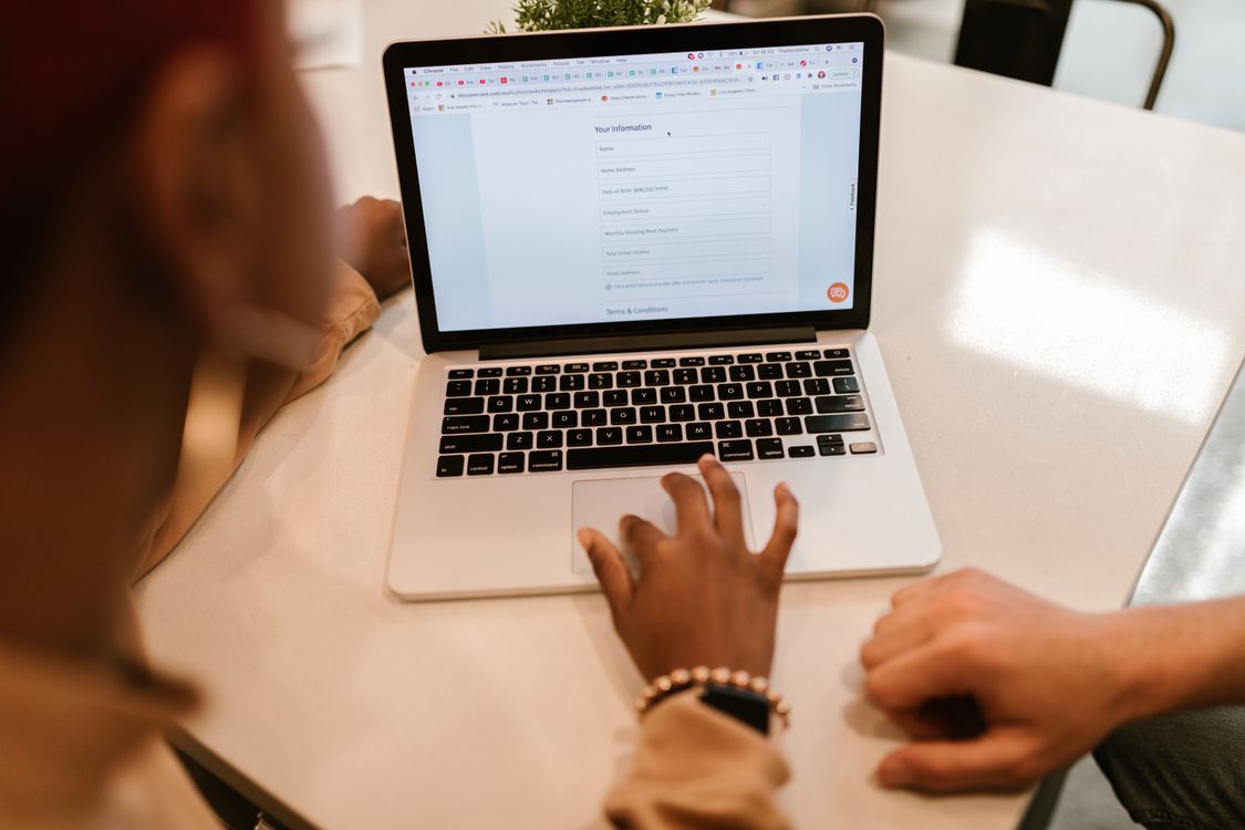 People filling out an online government job application form on a laptop