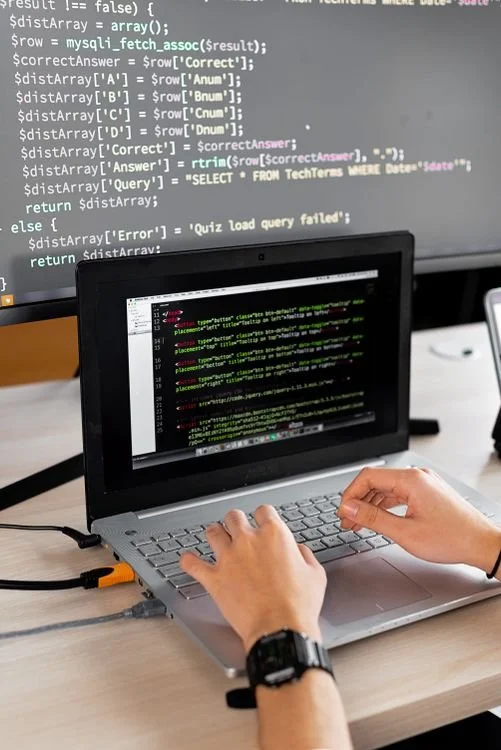 IT professional working on programming at a desk with an external monitor